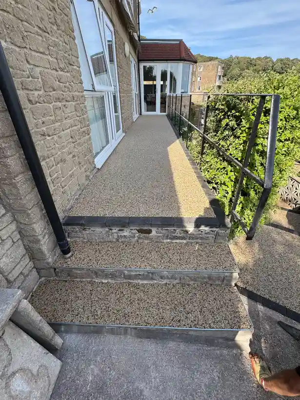Buff resin bound patio and steps connecting levels in a Bournemouth garden