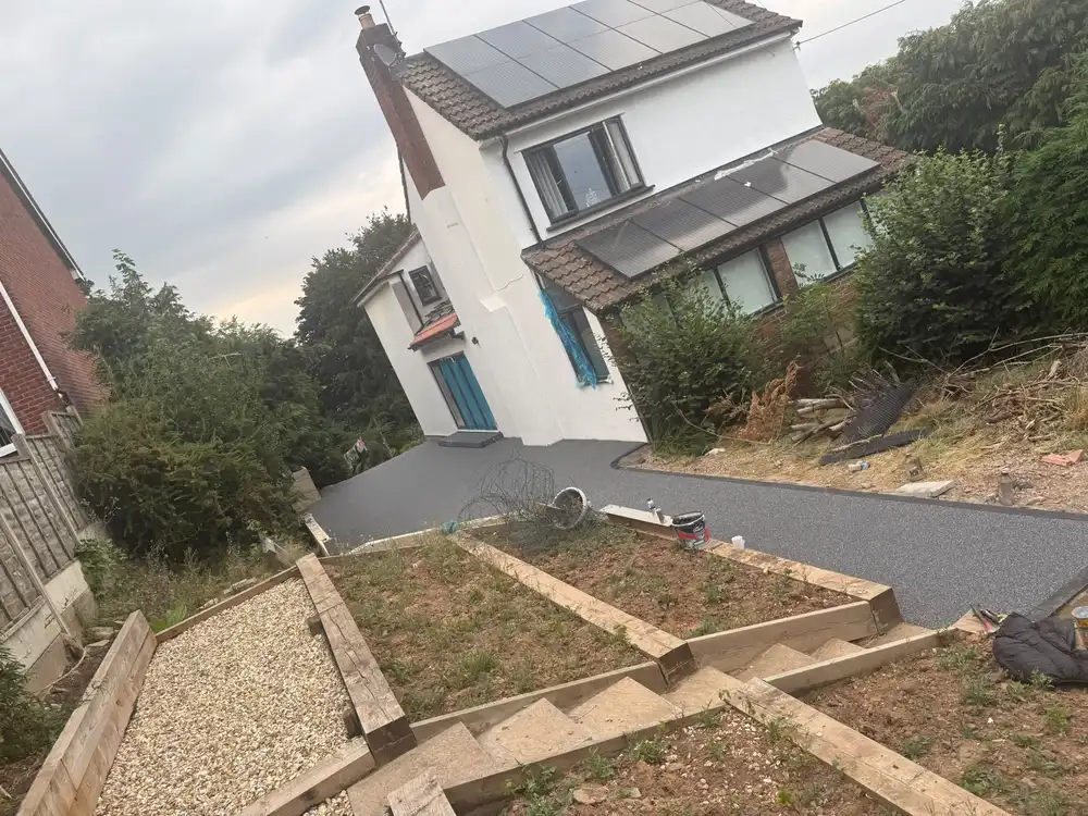 A grey resin bound driveway installed on a sloped plot at a detached Bournemouth home
