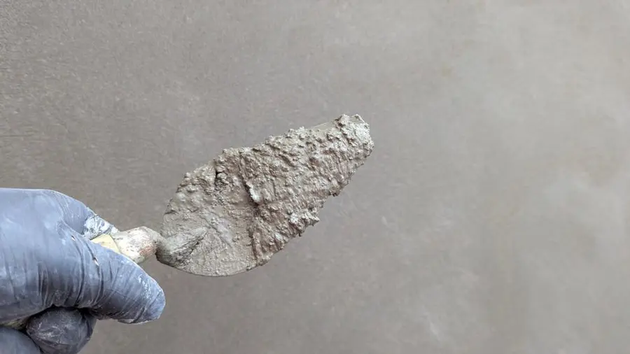 Fresh resin and aggregate being trowelled into a repair patch