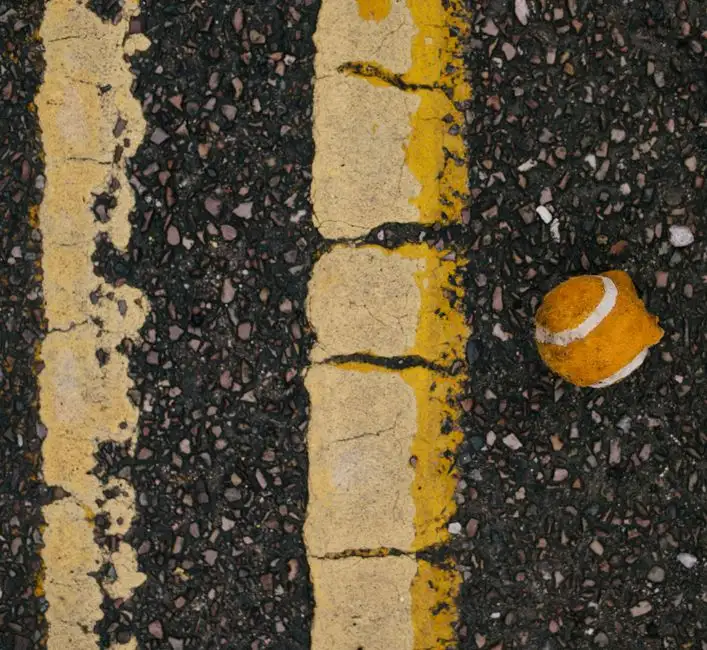 Old cracked tarmac driveway showing the typical deterioration pattern after ten or more years